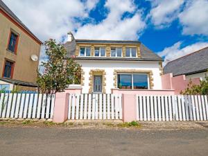 een roze en wit huis met een wit hek bij Villa is approx 100 metres from the Atlantic in Le Pouldu