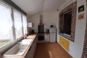 eine Küche mit Spüle und Ziegelwand in der Unterkunft Gîte Le temps suspendu à PEZOU 41 in Pezou