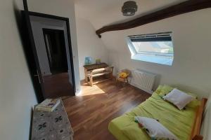 ein Wohnzimmer mit einem grünen Sofa und einem Fenster in der Unterkunft Gîte Le temps suspendu à PEZOU 41 in Pezou