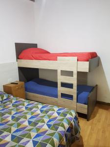 Dormitorio con litera y edredón colorido en Casa Grande en Neuquén