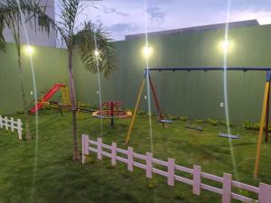 a play yard with swings and a fence at Recanto das Gerais in Passos
