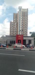 um carro branco estacionado em frente a um grande edifício em NH Studio Apartment Homestay em Wakaf Che Yeh