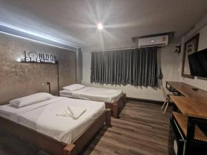 Postel nebo postele na pokoji v ubytování Pimpimarn Hotel
