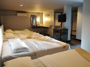 Postel nebo postele na pokoji v ubytování Pimpimarn Hotel