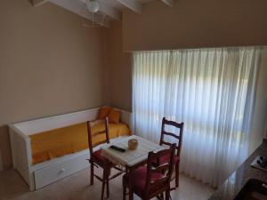 a small bedroom with a bed and a table and chairs at Departamento Necochea in Necochea