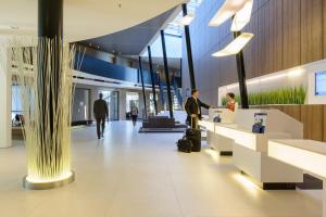 lobby lotniska z mężczyzną stojącym przy ladzie w obiekcie Novotel Hannover w Hanowerze