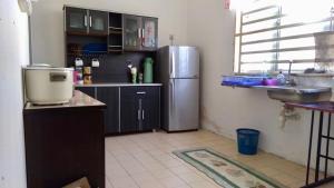 a kitchen with a refrigerator and a sink at Pak Lang Homestay in Kampung Gurun