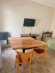 a wooden table and two chairs in a room at Javier in Santa Teresita