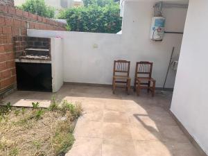 a patio with two chairs and a fireplace at Javier in Santa Teresita +1 photo