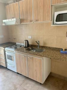 a kitchen with a sink and a stove top oven at Javier in Santa Teresita