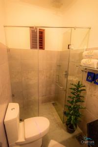 a bathroom with a toilet and a glass shower at Seethawaka Regency in Avissawella