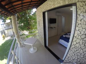 a room with a mirror on a balcony with a bed at Chalé 4, Maragogi, Condominio Village Galés in Maragogi