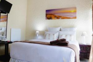 - une chambre avec un grand lit blanc et des serviettes dans l'établissement Moye Guest House, à Benoni