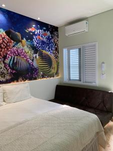 - une chambre ornée d'une peinture de poisson sur le mur dans l'établissement Suite Aquarius, à Guarujá