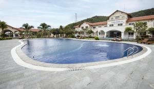 une grande piscine en face d'un bâtiment dans l'établissement Casa Maya Hotel, à ThÃ´n Báº£o An