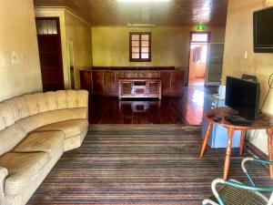 a living room with a couch and a television at Royal Carrangarra Hotel in Tambo