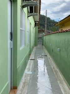 an empty hallway of a green building with water on the ground at Suite Aquarius in Guarujá