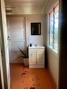 a bathroom with a white sink and a mirror at Royal Carrangarra Hotel in Tambo