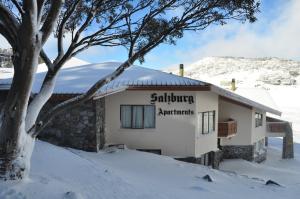 a building with a sign on it in the snow at Salzburg Apartments in Perisher Valley