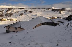 a building covered in snow on a snowy mountain at Salzburg Apartments in Perisher Valley