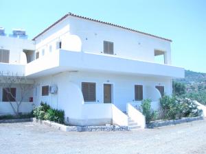 a white house with a hill in the background at Skoutari Beach Hotel in Skoutari