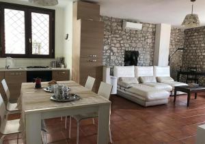 a kitchen and living room with a table and a couch at Le Camere Pinte in Sermoneta