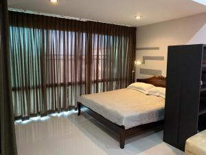 a bedroom with a bed and a large window at Condo AVANTA Deluxe A408 in Koh Samui 