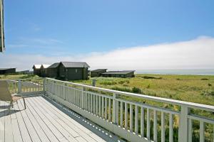 a wooden deck with a chair and a view of the ocean at Mandala Sands in Westport