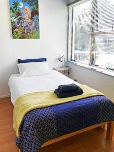 a bedroom with a bed with a blanket on it at Loeriewood Garden Apartment, Hunters Home in Knysna