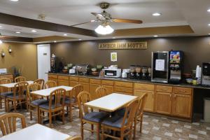 a restaurant with tables and chairs and a counter at Amber Inn in Le Mars