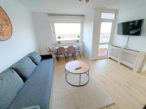 ein Wohnzimmer mit einem Sofa und einem Tisch in der Unterkunft Ferienwohnung Seestern 78 in Bremerhaven