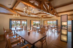 a restaurant with wooden tables and chairs and chandeliers at The Seaes Hotel & Resort in Seogwipo