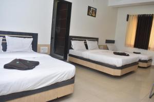 Rúm í herbergi á HOTEL SAI VISHVA KARMA