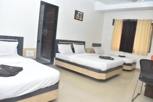 Rúm í herbergi á HOTEL SAI VISHVA KARMA
