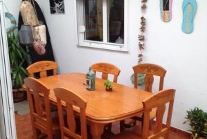 a wooden dining room table with four chairs and a window at KAKTUS BEACH House in Corralejo