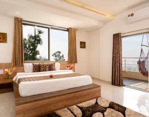 a bedroom with a large bed and a large window at Hotel Mahabaleshwar Fragrance in Mahabaleshwar
