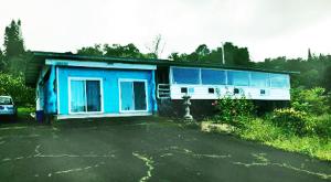 a blue house with a fire hydrant in front of it at Aeolian Ranch in Kailua-Kona