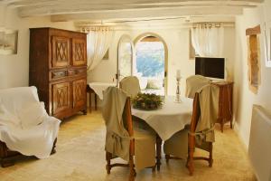 uma sala de jantar com uma mesa e uma televisão em Le Castélas em Aiguèze