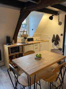 una cocina con una mesa de madera con manzanas. en La Maison Sévigné - Appart Hôtel - N°6 L'indus, en Béthune