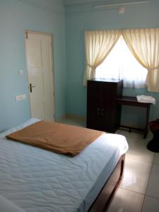 a bedroom with a bed and a desk and a window at ZaMaRaYa Bed & Breakfast in Angamali