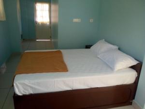 a bed with white sheets and pillows in a room at ZaMaRaYa Bed & Breakfast in Angamaly
