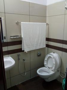 a bathroom with a white toilet and a sink at ZaMaRaYa Bed & Breakfast in Angamali