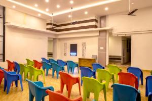 a room with colorful chairs and a podium at Oaks Residency in Bekal