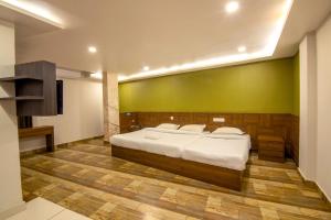Un dormitorio con una cama grande y una pared verde en Oaks Residency en Bekal