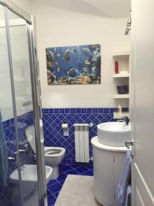 a blue tiled bathroom with a toilet and an aquarium at VILLA VISTA MARE INFINITY POOL in Santa Marinella