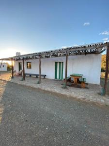 a white building with a picnic table in front of it at Waterval farmstay in Graaff-Reinet