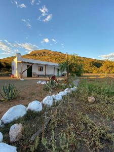 a house in the middle of a field with rocks at Waterval farmstay in Graaff-Reinet