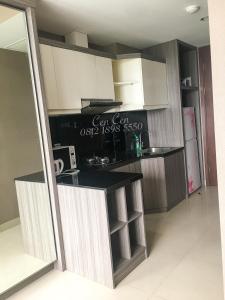 a kitchen with white cabinets and a black counter top at Near Aryaduta, Siloam Hospital, UPH. U Residence Apartment for Stay in Tangerang