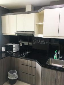 a kitchen with white cabinets and a sink at Near Aryaduta, Siloam Hospital, UPH. U Residence Apartment for Stay in Tangerang
