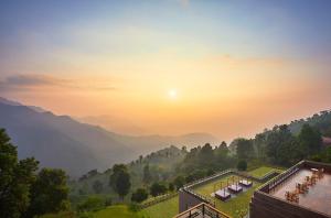 een uitzicht op de bergen vanuit een resort met zonsondergang bij Taj Chia Kutir Resort & Spa Darjeeling in Kurseong